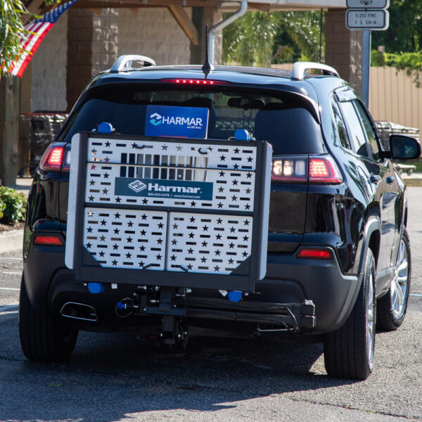 Harmar AL500HD Universal Powerchair Lift on SUV, showing adjustable platform and hold-down arm.