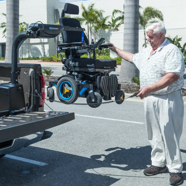 Harmar AL425 Hoist Lift installed in a van cargo area, showcasing powered lifting and rotation for easy mobility device transport.