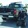 Harmar AL425 Hoist Lift installed in a van cargo area, showcasing powered lifting and rotation for easy mobility device transport.