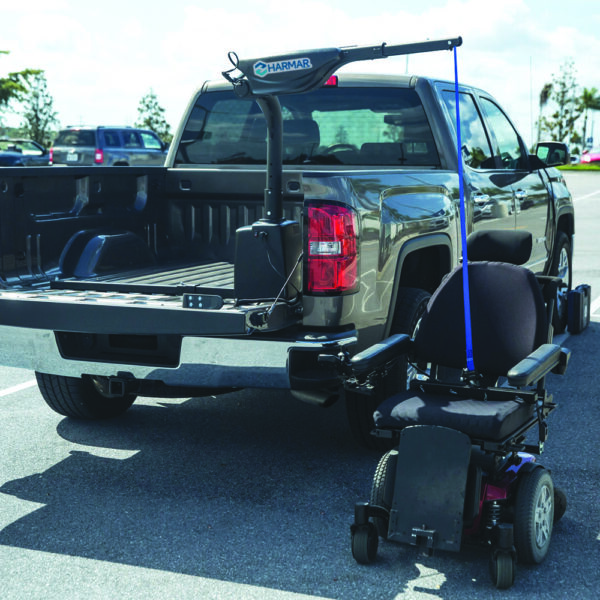 Harmar AL425 Hoist Lift installed in a van cargo area, showcasing powered lifting and rotation for easy mobility device transport.