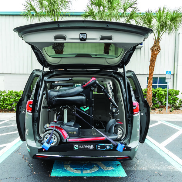 Compact Harmar AL6000 Inside Platform Lift installed in SUV, providing secure transport for powerchairs and scooters.