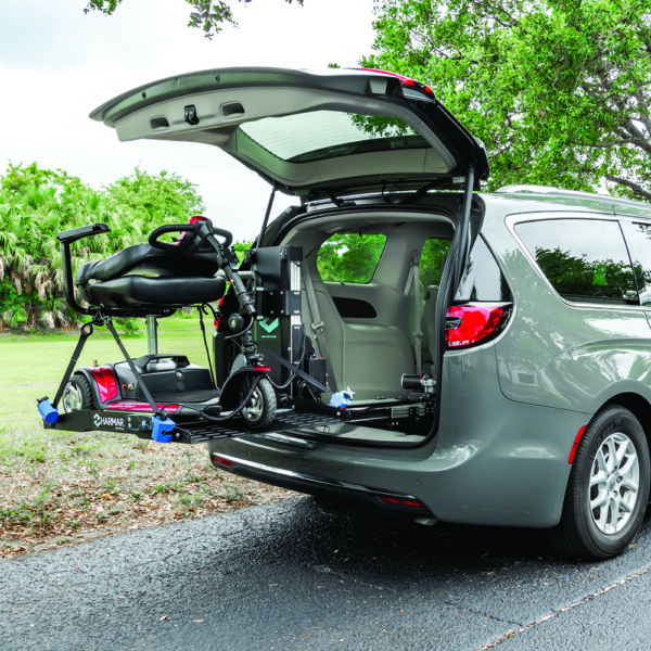 Compact Harmar AL6000 Inside Platform Lift installed in SUV, providing secure transport for powerchairs and scooters.