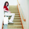 SL350AC_LIfestyle_09_AscentRedShirt_lpr Harmar SL350AC Stairlift installed indoors, showing a wide padded seat, adjustable footrest, and sturdy aluminum track.