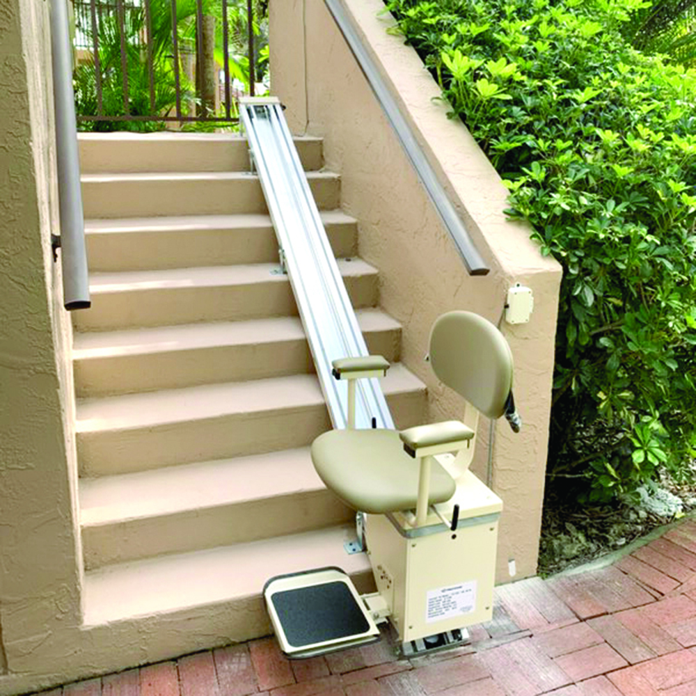 Harmar Summit Outdoor Stairlift installed on an outdoor staircase, featuring durable aluminum track and weatherproof vinyl seating.