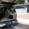 Harmar AL435 3-Way Inside Lift installed in a vehicle cargo area, showcasing its powered lifting, rotating, and extending functions for mobility device transport.