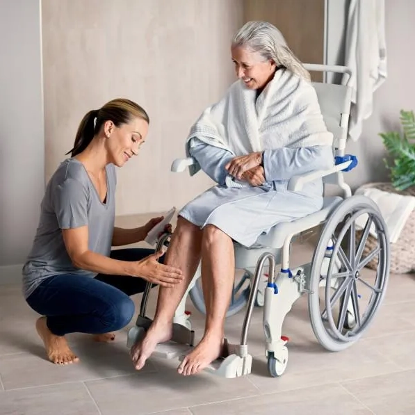 Aquatec Ocean Ergo Self-Propel Shower Commode Chair with ergonomic seat, 24-inch wheels, height-adjustable armrests, and included collection pan.