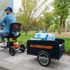Explorer Mobility Scooter in black and orange, sturdy frame, pneumatic tires, ergonomic handlebars, and control panel for easy operation.