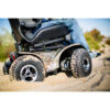 Extreme X8 Extreme X8 Power Wheelchair navigating rugged outdoor terrain with knobby tires and a sturdy design, built for sand, snow, and off-road adventures.
