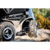 Extreme X8 2 Extreme X8 Power Wheelchair navigating rugged outdoor terrain with knobby tires and a sturdy design, built for sand, snow, and off-road adventures.