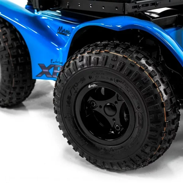 Extreme X8 Power Wheelchair navigating rugged outdoor terrain with knobby tires and a sturdy design, built for sand, snow, and off-road adventures.