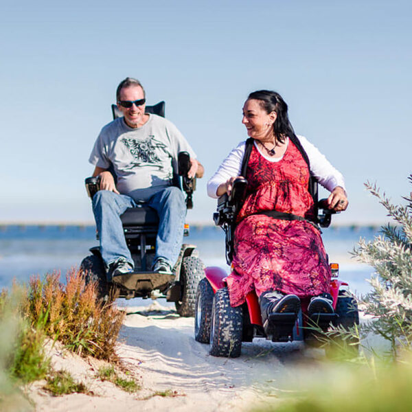 Extreme X8 Power Wheelchair navigating rugged outdoor terrain with knobby tires and a sturdy design, built for sand, snow, and off-road adventures.