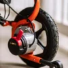 GoRide 2 Electric Wheelchair in orange, foldable aluminum frame, padded seat, 12” rear wheels, and ergonomic joystick controls.