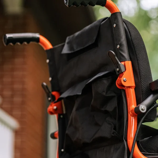 GoRide 2 Electric Wheelchair in orange, foldable aluminum frame, padded seat, 12” rear wheels, and ergonomic joystick controls.